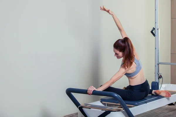 Pilates riformatore esercizi di allenamento donna bruna in palestra al coperto — Foto Stock