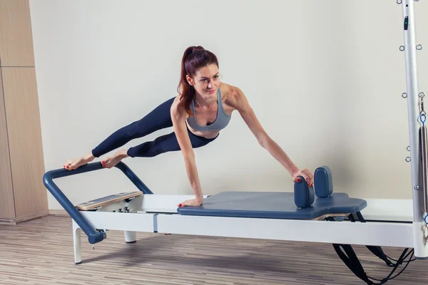 Pilates hervormer training oefeningen vrouw brunette op sportschool binnen — Stockfoto