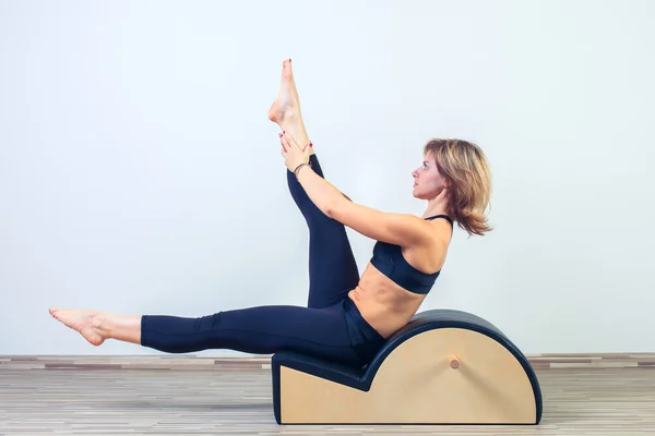 Pilates, fitness, deporte, entrenamiento y concepto de personas - mujer haciendo ejercicios en barril pequeño — Foto de Stock