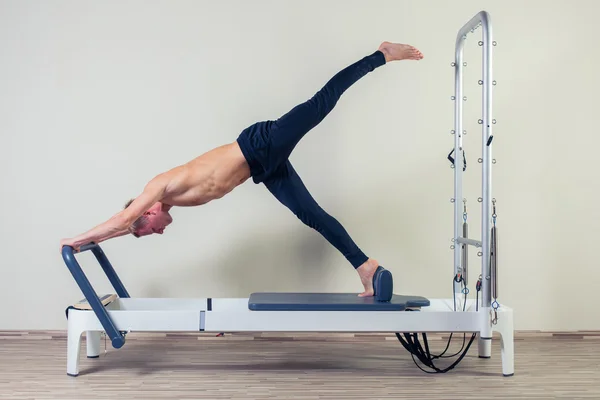 Pilates reformador exercícios homem no ginásio indoor — Fotografia de Stock