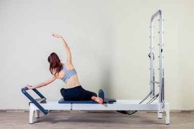 Kapalı spor salonunda Pilates reformer Egzersiz Egzersizler kadın esmer