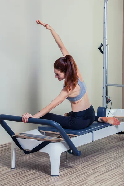 Μελαχρινή γυναίκα ασκήσεις pilates αναμορφωτήρα προπόνηση στο γυμναστήριο και εσωτερική — Φωτογραφία Αρχείου