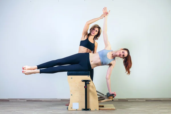 Combo wunda pilates silla mujer con instructor fitness yoga gimnasio ejercicio — Foto de Stock