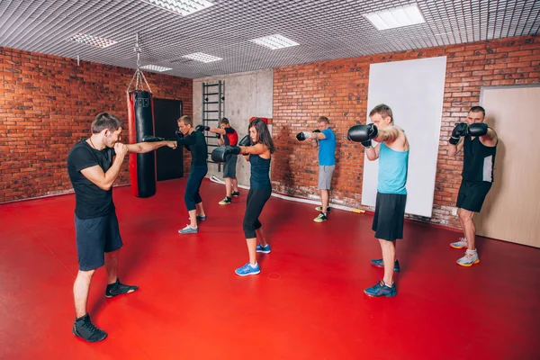 Boxen Aerobox-Gruppe mit Personal Trainer Mann im Fitnessstudio, Handschuhe, Boxsack — Stockfoto