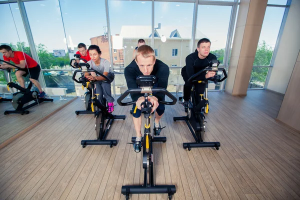Grupo de personas del gimnasio en máquinas, ciclismo en clase — Foto de Stock