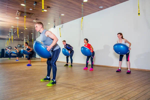 Persone al centro benessere con personal trainer, imparare la forma corretta. bosu — Foto Stock