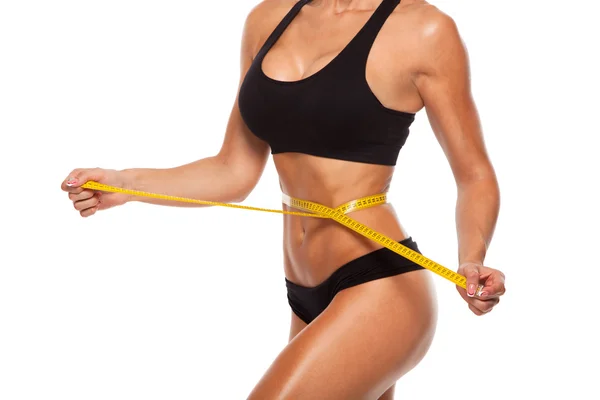 Hermoso cuerpo deportivo de mujer con medida amarilla sobre fondo blanco —  Fotos de Stock