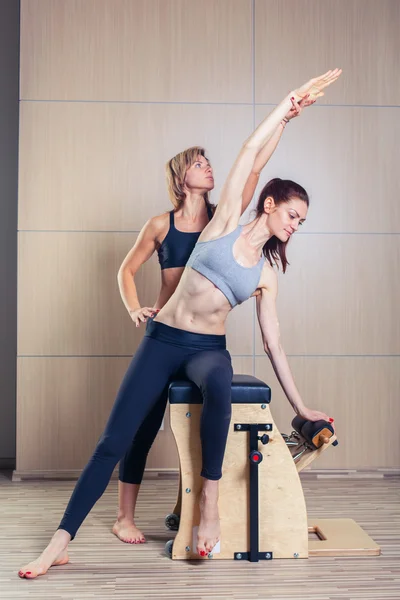 Combo wunda pilates silla mujer con instructor fitness yoga gimnasio ejercicio . — Foto de Stock