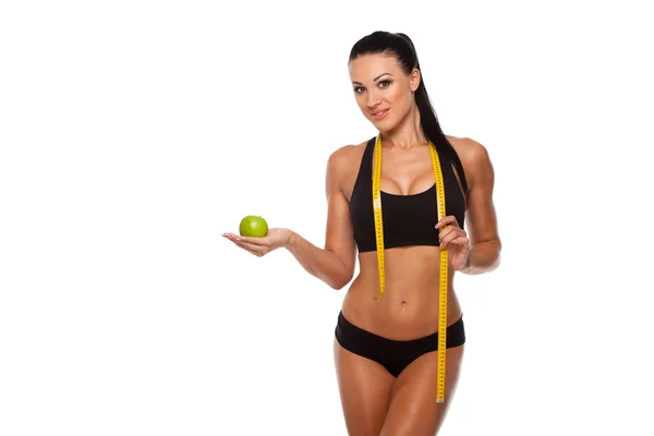 Sporty woman waist with measure tape and green apple isolated on white — Stock Photo, Image
