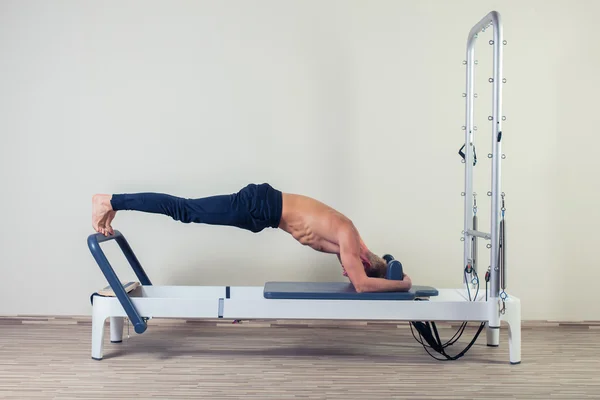 Pilates reformador exercícios homem no ginásio indoor — Fotografia de Stock