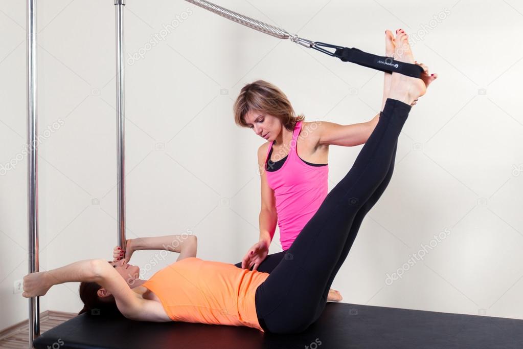 Pilates aerobic instructor woman with in cadillac fitness exercise