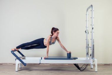 Kapalı spor salonunda Pilates reformer Egzersiz Egzersizler kadın esmer