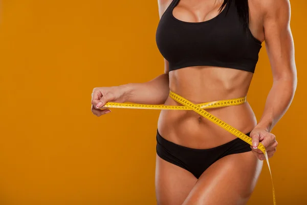 Concepto de deporte, fitness y dieta: primer plano del vientre entrenado con cinta métrica —  Fotos de Stock