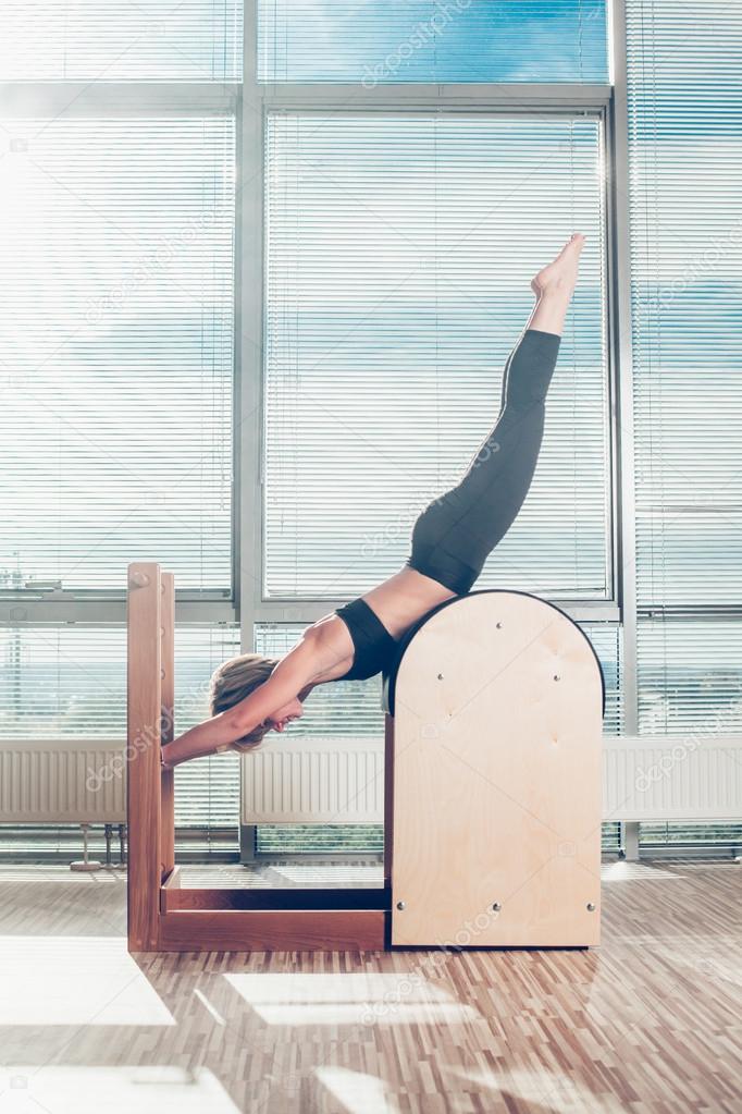 Pilates, fitness, sport, training and people concept - smiling woman doing  exercises on ladder barrel Stock Photo by ©satyrenko 90564174