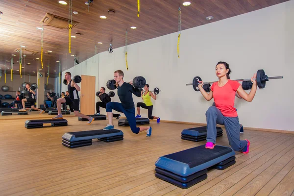 Spor, fitness, yaşam tarzı ve insanlar kavramı - grup salonunda barbell ile kasları esneme — Stok fotoğraf