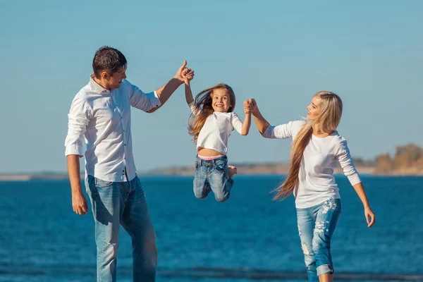 Lyckliga familjen som spelar på stranden. Begreppet vänlig familjens — Stockfoto