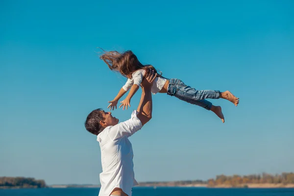Vater und Tochter spielen tagsüber am Strand. fliegen — Stockfoto