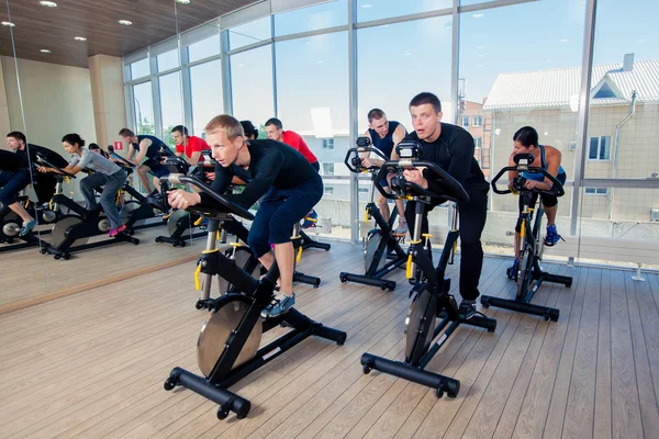 Grupo de personas del gimnasio en máquinas, ciclismo en clase — Foto de Stock