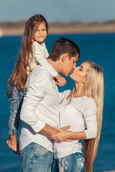 청바지 물 배경 포옹에 젊은 가족 — 스톡 사진