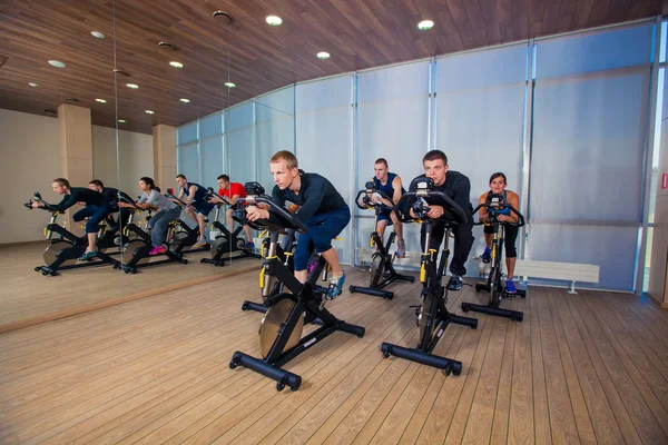 Grupo de personas del gimnasio en máquinas, ciclismo en clase — Foto de Stock