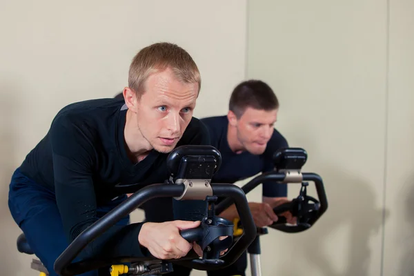 Gruppo di persone palestra su macchine, ciclismo in classe — Foto Stock