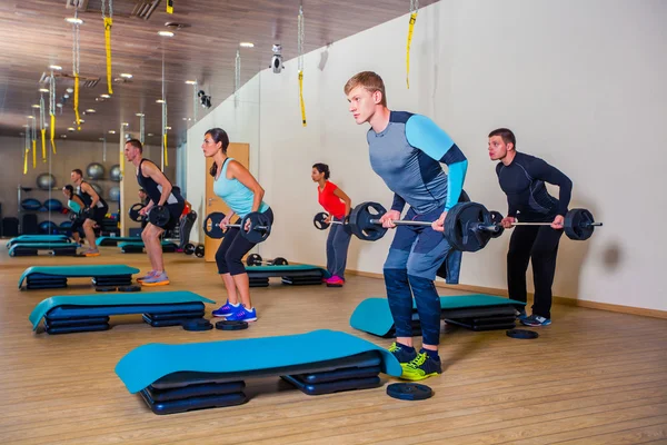 Spor, fitness, yaşam tarzı ve insanlar kavramı - grup salonunda barbell ile kasları esneme — Stok fotoğraf