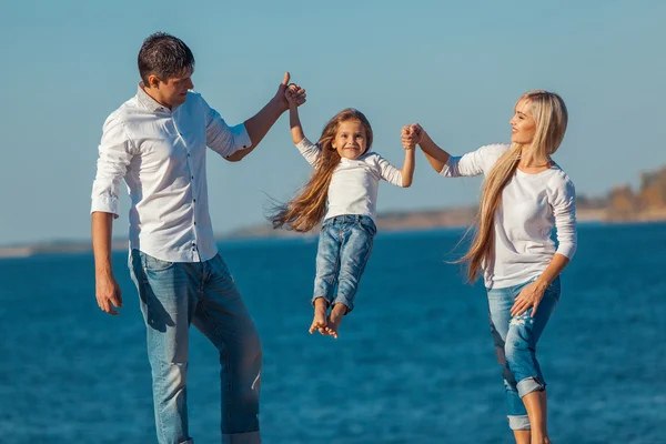 Família feliz que joga na praia. Conceito de famílias amigáveis — Fotografia de Stock