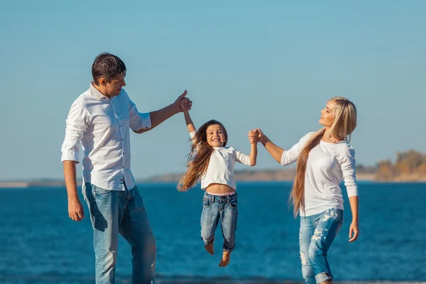 Счастливая семья, которая играет на пляже. Концепция дружественных семей — стоковое фото