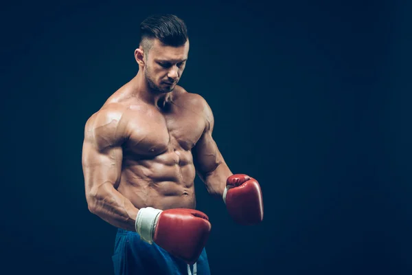 Boxer muscolare in studio di tiro, su sfondo nero . — Foto Stock