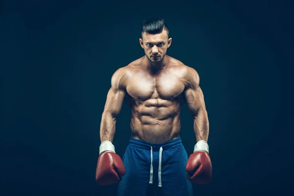 Boxer muscolare in studio di tiro, su sfondo nero . — Foto Stock