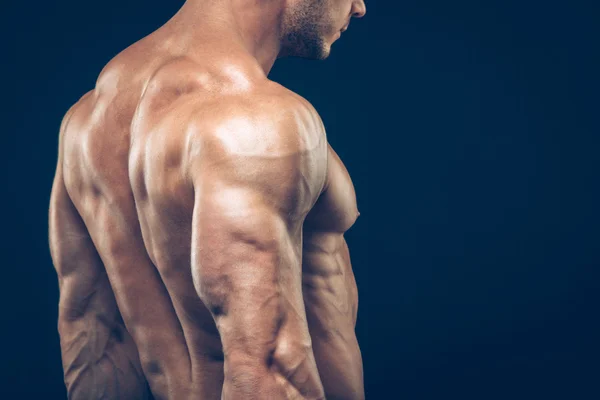 Strong athletic man back on dark background — Stock Photo, Image