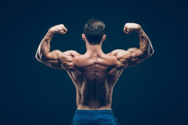 Kaslı adam siyah arka plan üzerinde koyu Studio poz.