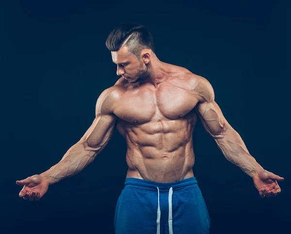 Strong athletic man on black background — Stock Photo, Image