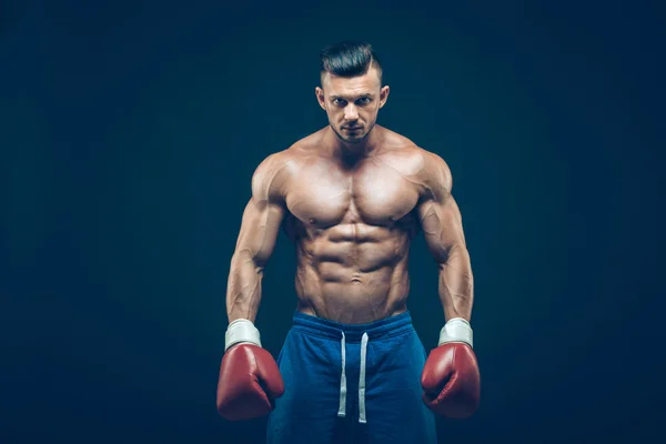 Boxeador muscular en rodaje de estudio, sobre fondo negro . — Foto de Stock