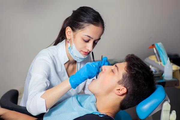 Mann lässt Zähne beim Zahnarzt untersuchen — Stockfoto