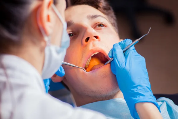 Mann lässt Zähne beim Zahnarzt untersuchen — Stockfoto