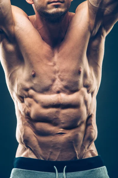 Starker athletischer Mann Fitness-Modell Oberkörper zeigt Sixpack Bauchmuskeln. isoliert auf schwarzem Hintergrund mit Copyspace — Stockfoto