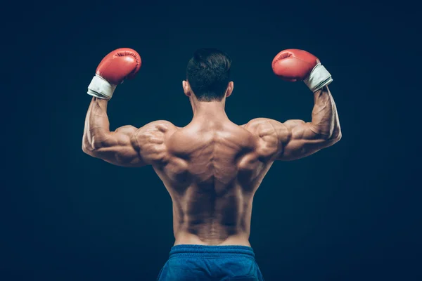 Boxer muscolare in studio di tiro, su sfondo nero . — Foto Stock