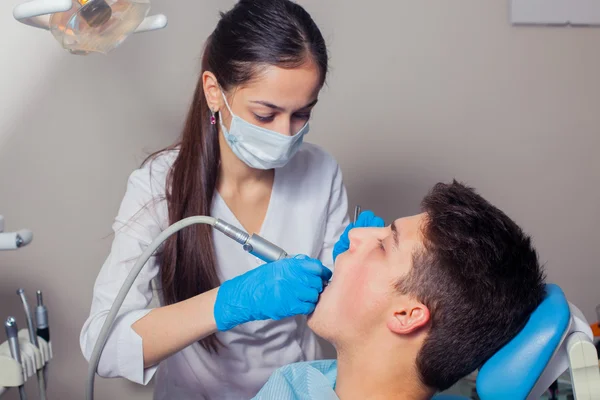 Mann lässt Zähne beim Zahnarzt untersuchen — Stockfoto