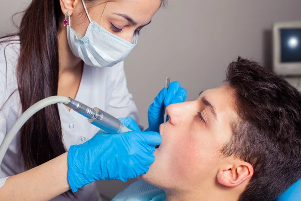 Mies, jonka hampaat tarkastetaan hammaslääkärissä — kuvapankkivalokuva