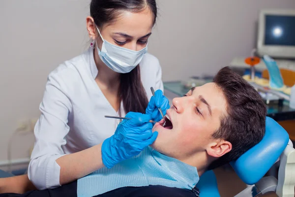 Mies, jonka hampaat tarkastetaan hammaslääkärissä — kuvapankkivalokuva