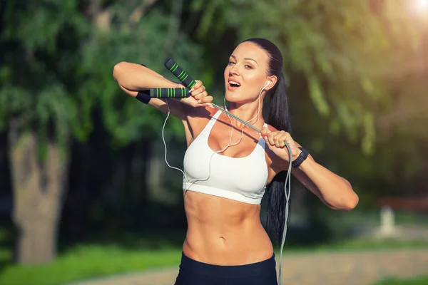 Fitness och livsstil koncept - kvinna sportaktiviteter utomhus. flicka med hopprep — Stockfoto