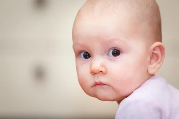 Close-up de uma criança pequena que chora, mas não grita. Uma lágrima a rolar pela bochecha abaixo. Fundo desfocado. Foto menina . — Fotografia de Stock