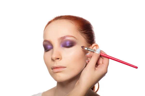 Professional Make-up artist gör glamour med rött hår modell makeup. Isolerade bakgrund. — Stockfoto