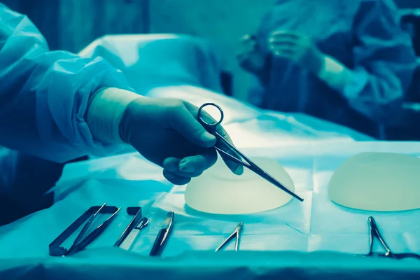 Nurse hand taking surgical instrument for group of surgeons at b — Stock Photo, Image