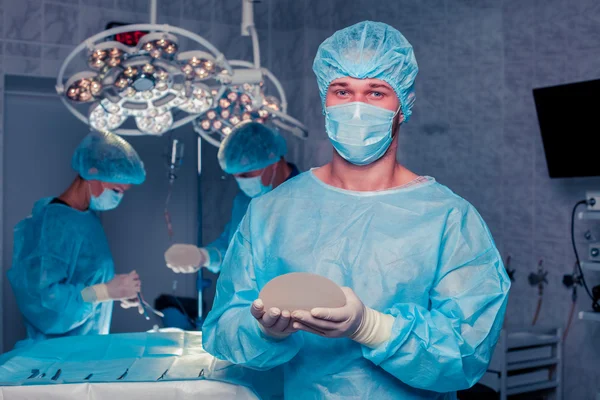 Chirurgien d'équipe au travail en salle d'opération. augmentation mammaire . — Photo