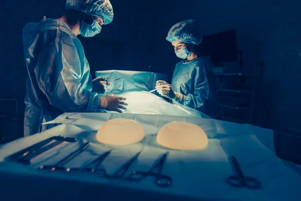 Equipe de Cirurgiões que trabalha com Monitoramento do paciente em centro cirúrgico. aumento da mama — Fotografia de Stock