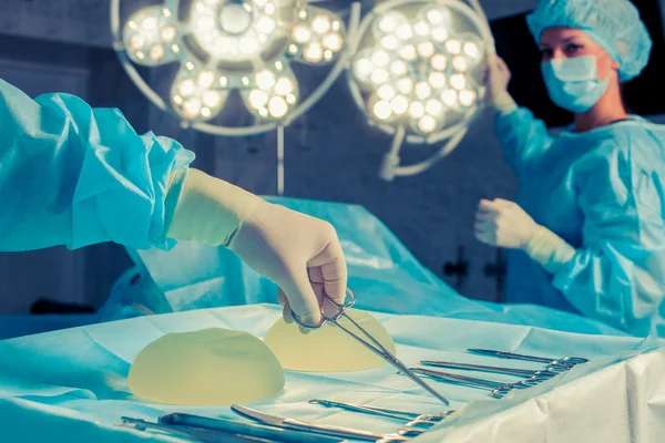 Sjuksköterska hand med kirurgiska instrument för grupp kirurger på b — Stockfoto