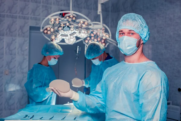 Chirurgien d'équipe au travail en salle d'opération. augmentation mammaire . — Photo