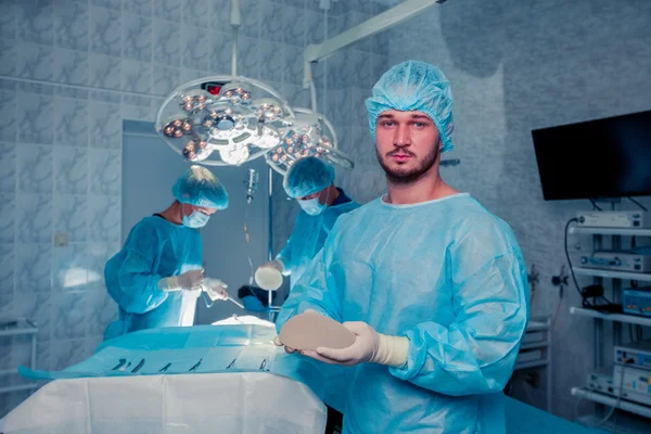 Chirurgien d'équipe au travail en salle d'opération. augmentation mammaire . — Photo